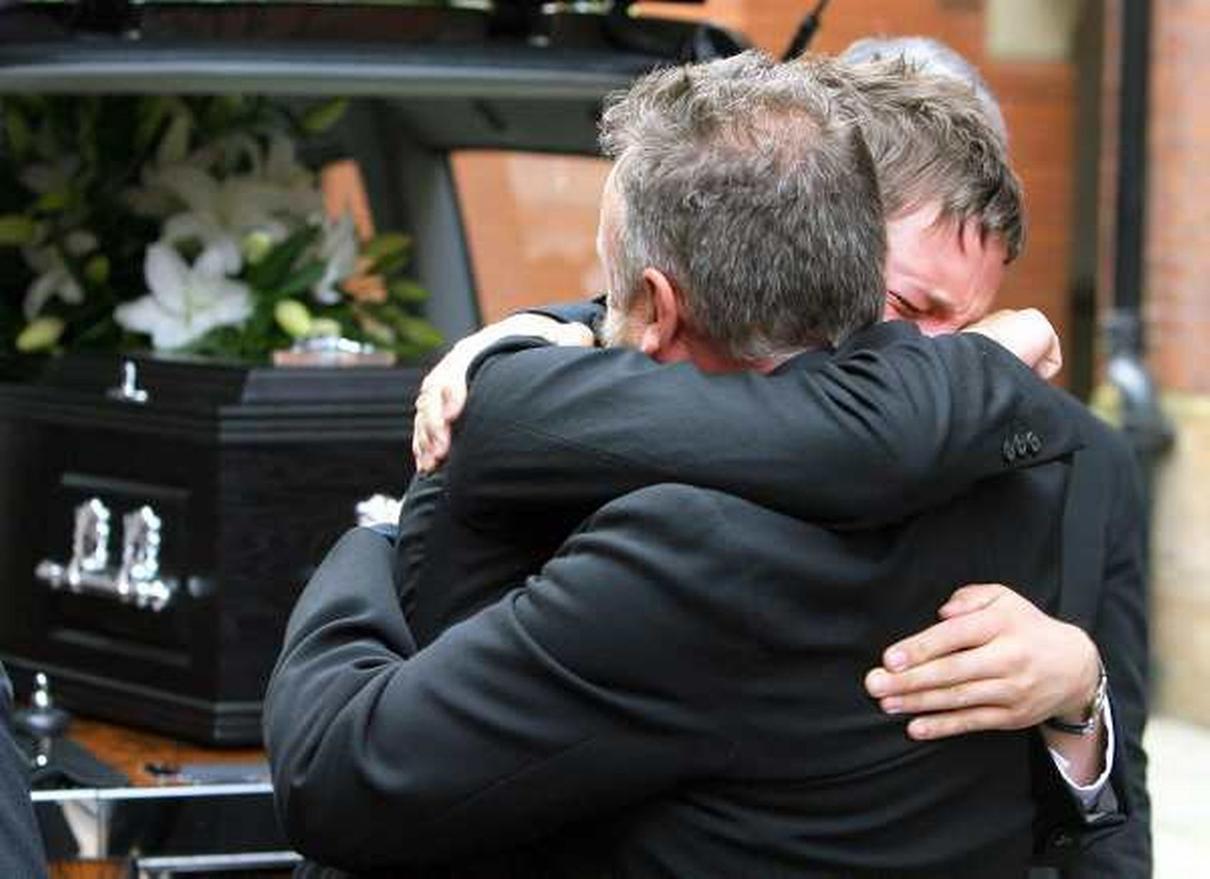 Tony's son Oliver hugs Peter Hook.